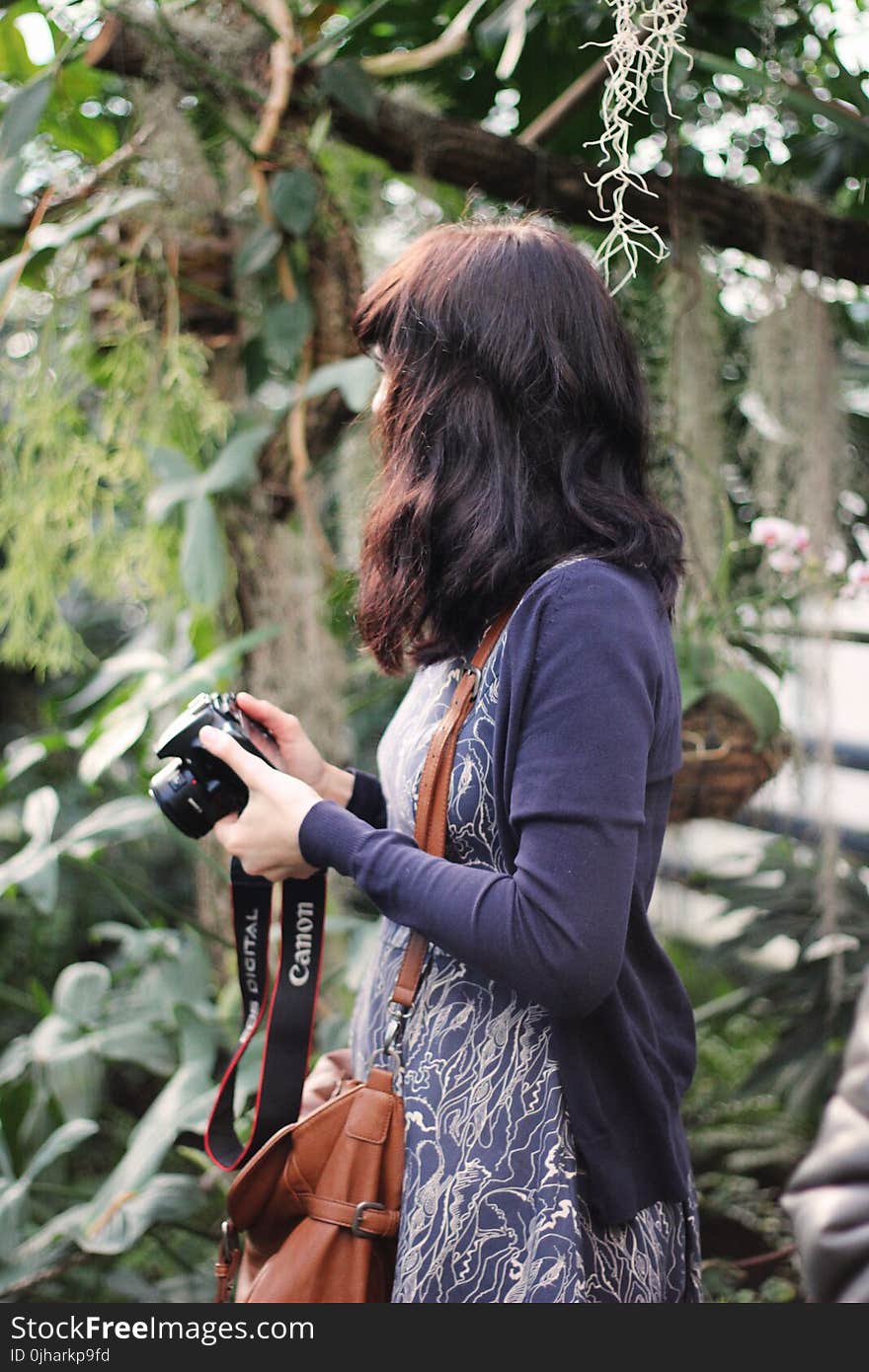 Woman in Blue Cardigan Holding Canon Dslr Camera