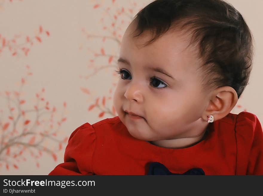 Baby Wearing Red Crew-neck Shirt Near Pink and Black Floral Surface