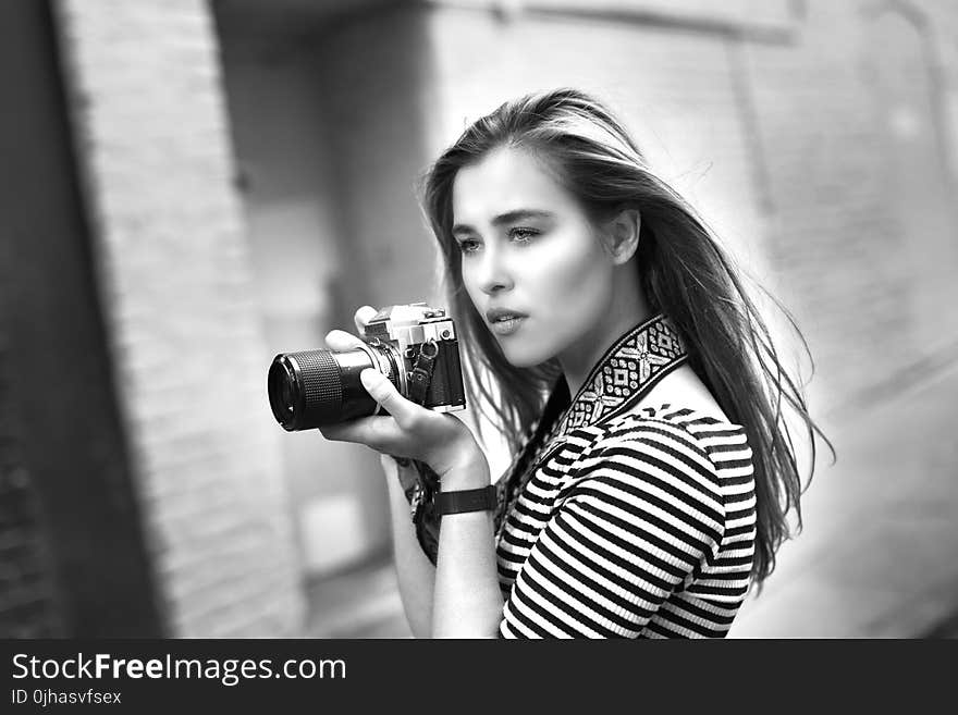 Grayscale Photo of Woman Holding a Dslr Camera