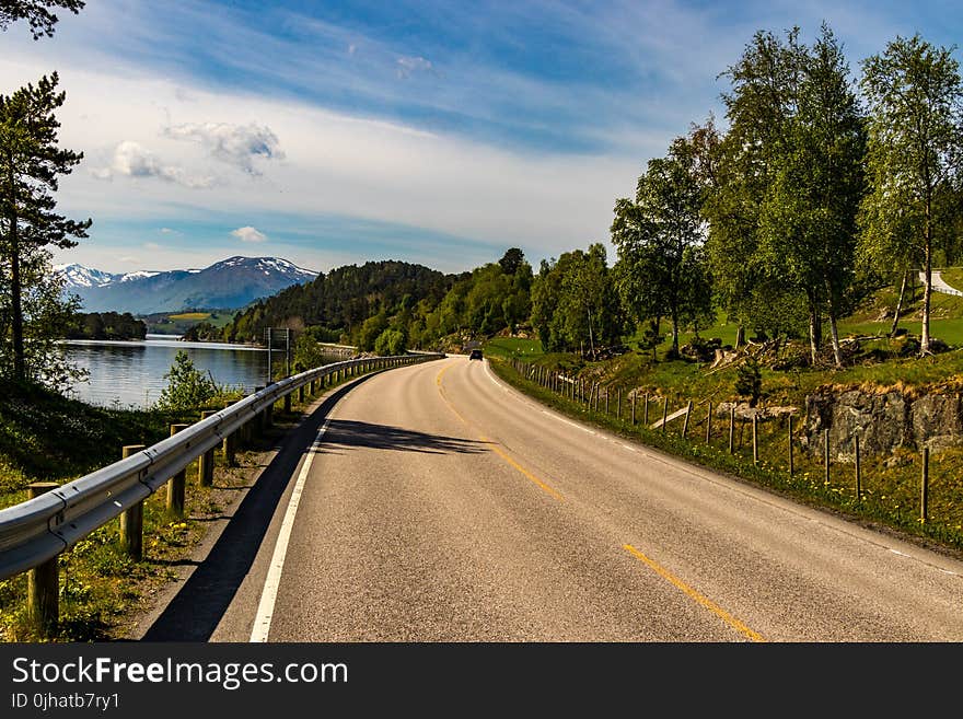 Brown Asphalt Road Beside Lake