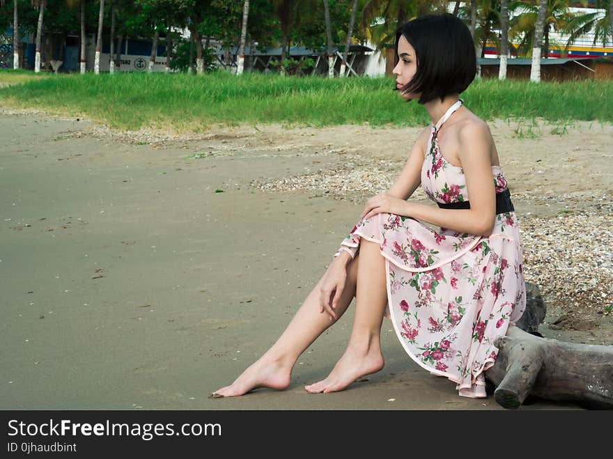 Woman in Pink Floral Halter Dress Seating in Driftwood