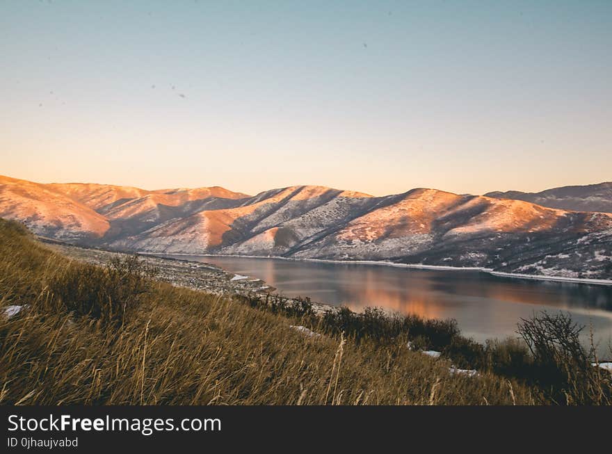 Mountains Near Lake Under Blue Sky