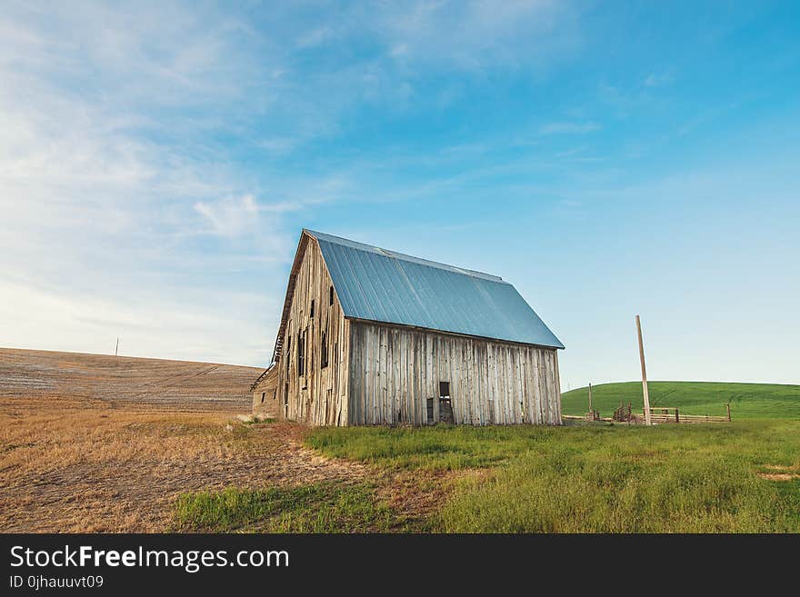 Photo of Beige and Gray Wooden Barn House on Green Grass