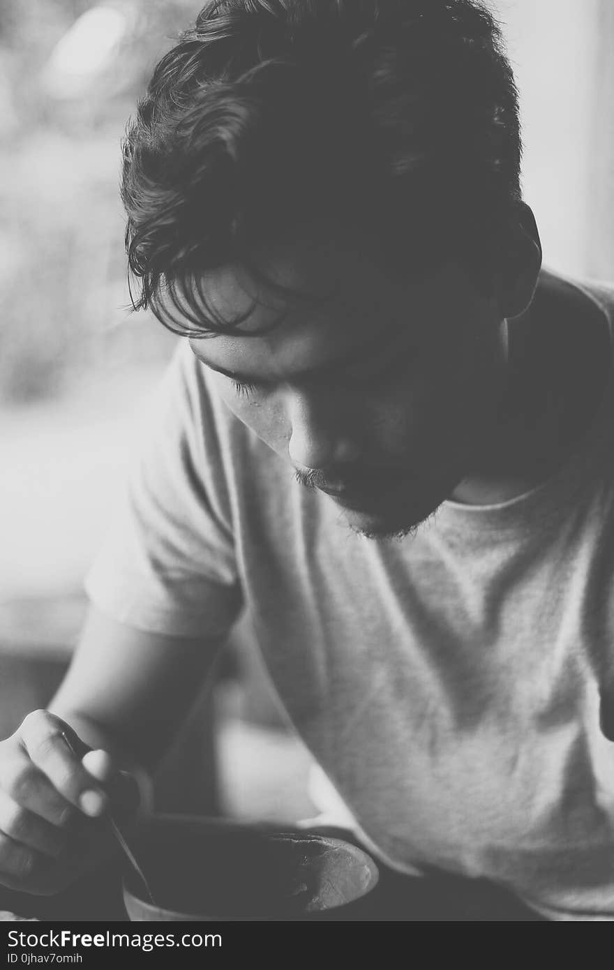 Gray Scale Photo of Man Eating