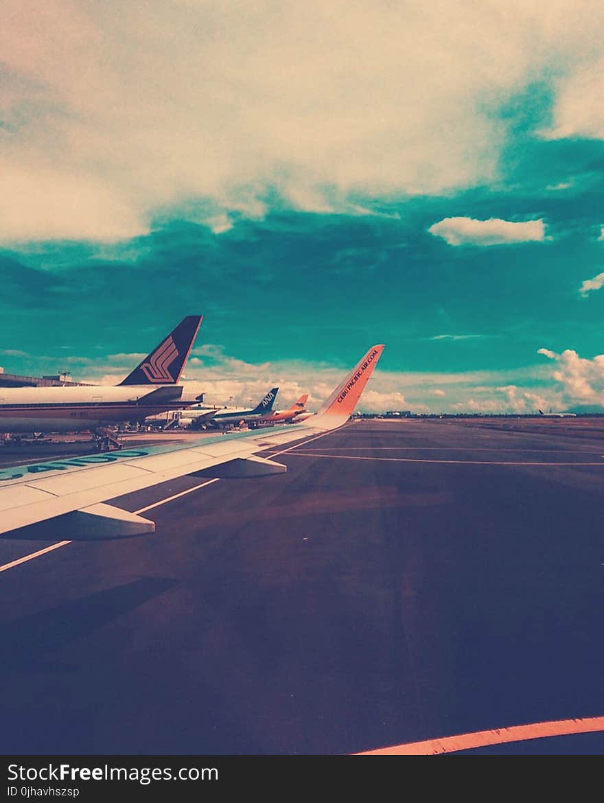 Plane on Airport Under Cloudy Sky at Daytime