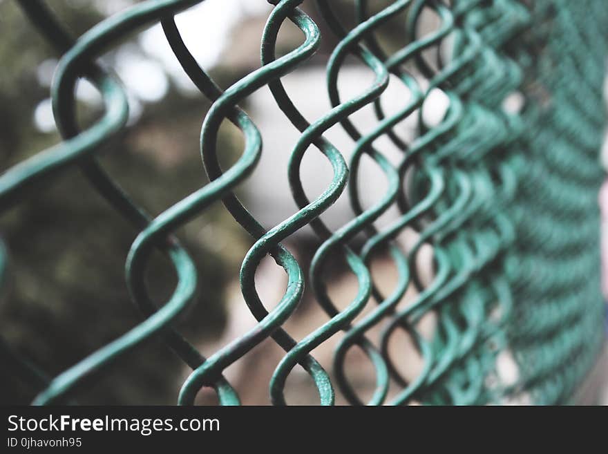 Selective Focus Photography of a Green Link Fence