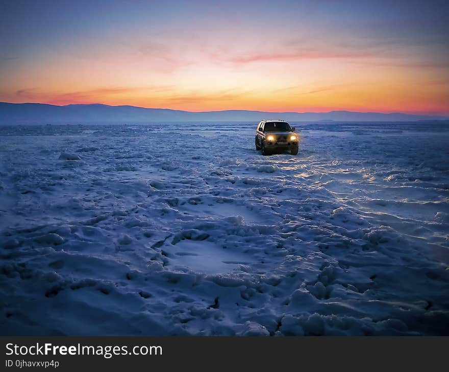 Black Suv on Snow during Golden Hour