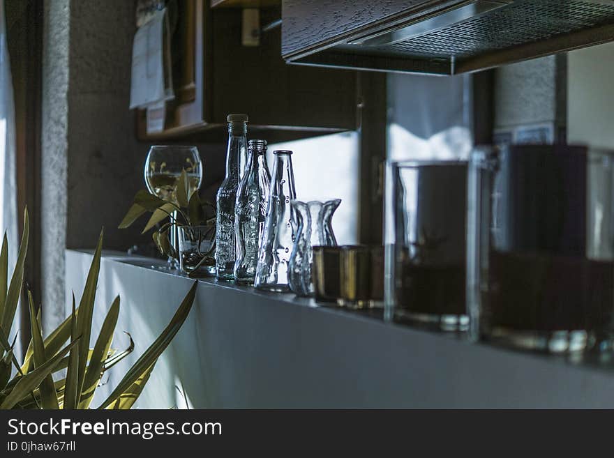 Assorted Clear Glass Bottles With Wine Glass in the Shelf