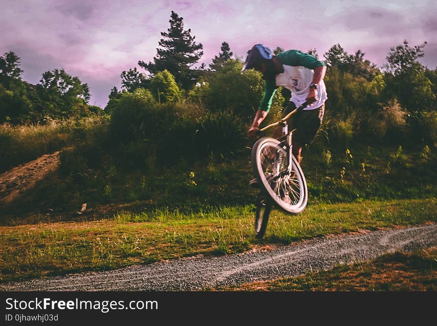 Man in White and Green Raglan Elbow-sleeved Shirt Biking at Daytime