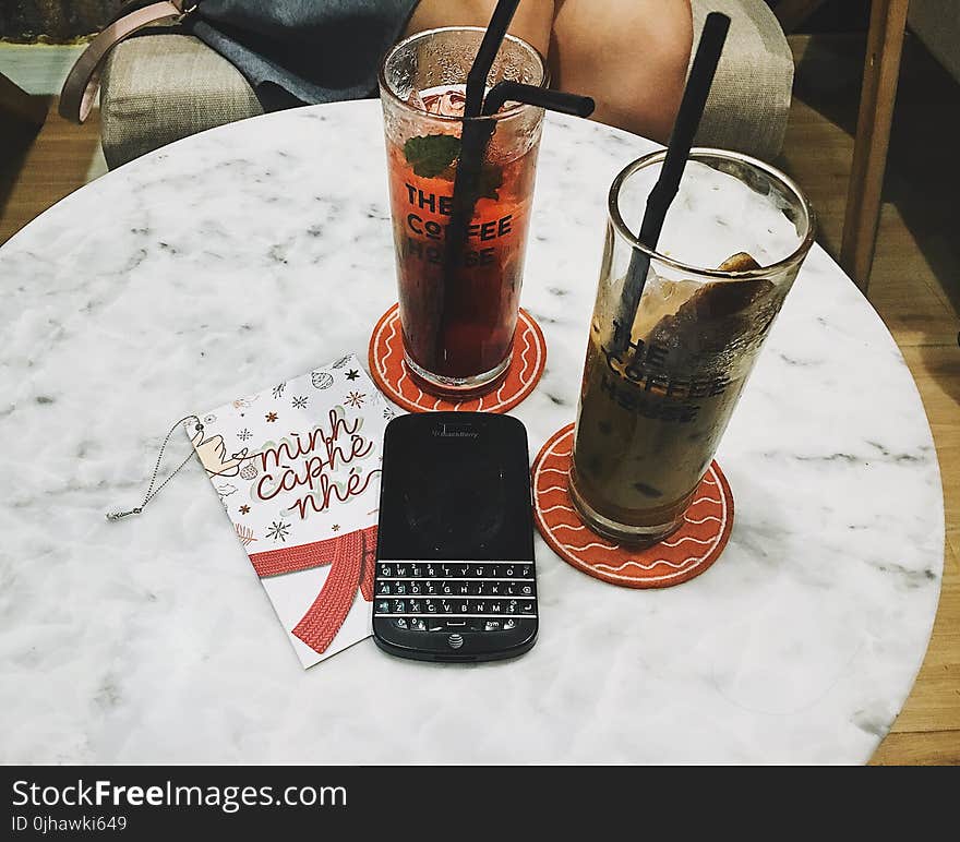 Photo of Blackberry Phone Beside Two Tall Glasses