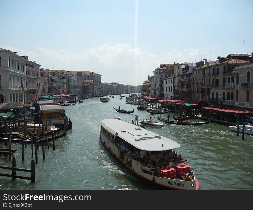 Gray Buildings Near Body of Water With Boats at Daytime