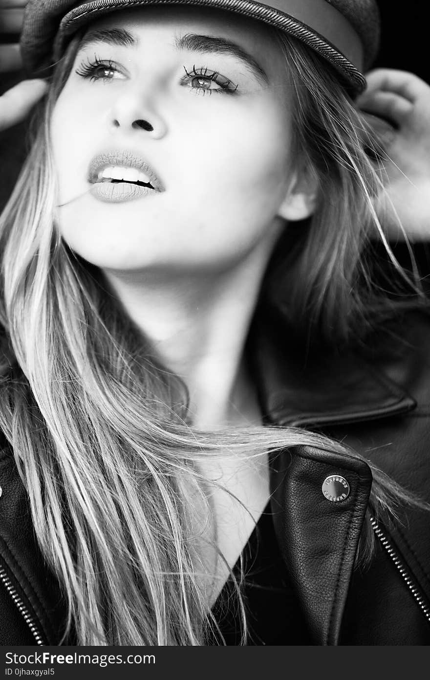 Grayscale Photography of Woman Wears Leather Jacket and Cap