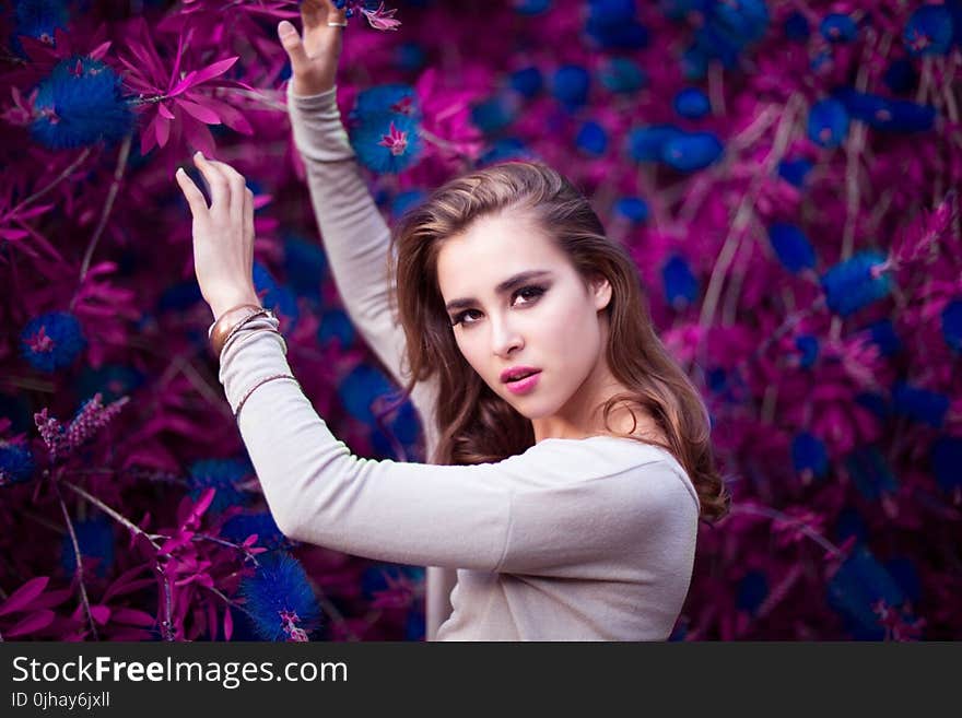 Woman Holding Purple and Blue Flowers