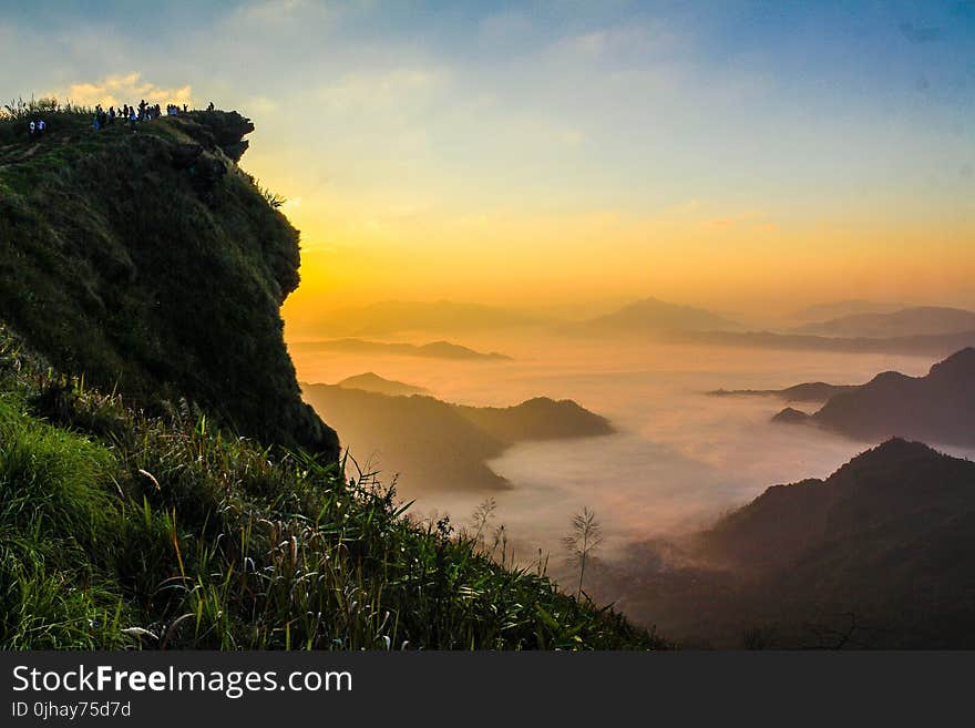 Landscape Photography of Cliff With Sea of Clouds during Golden Hour