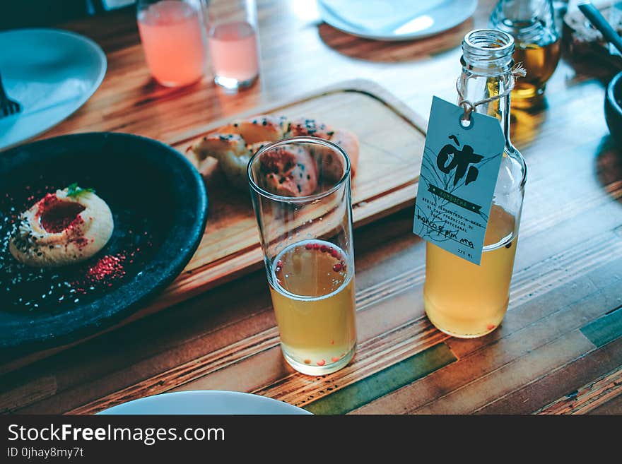 Clear Glass Bottle and Drinking Glass With Brown Liquid