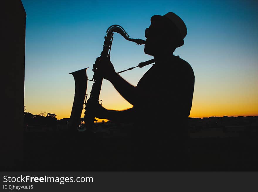 Silhouette of a Man Playing Saxophone during Sunset