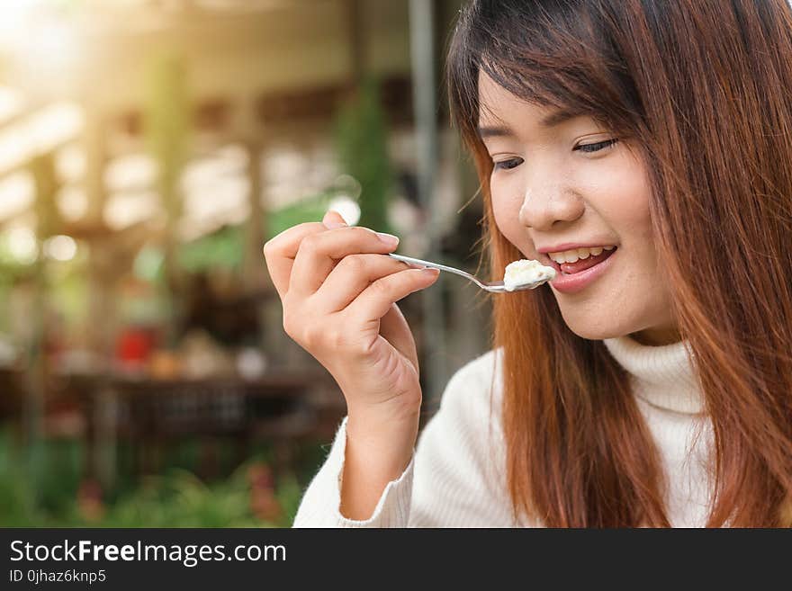 Woman Holding Spoon Trying to Eat White Food