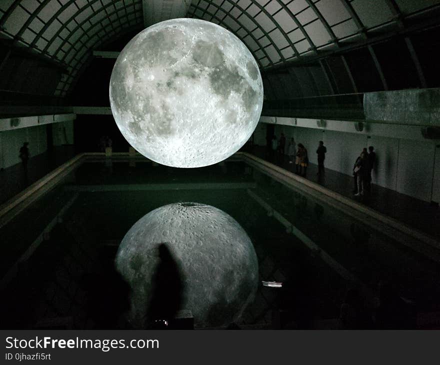 Photo of Moon Hologram Floating on Water Near People Inside Room