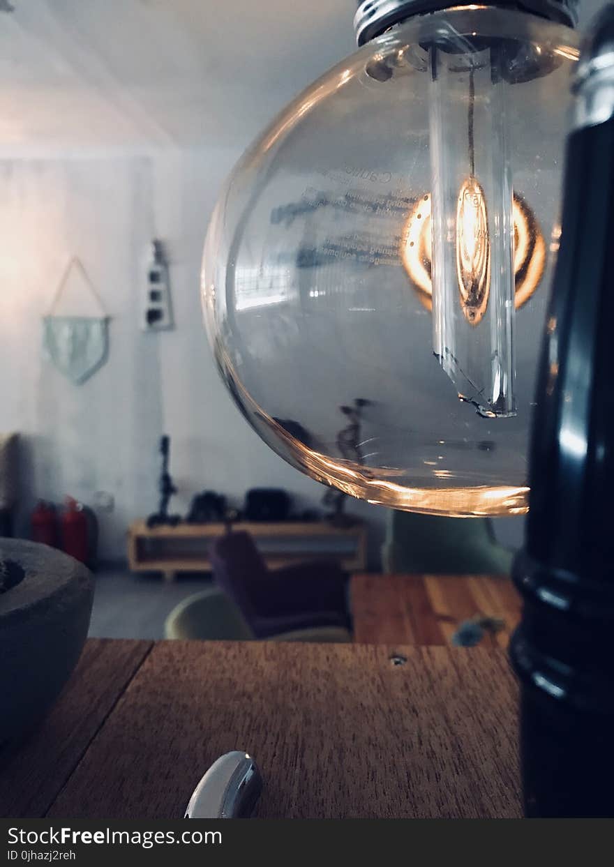 Clear Glass Lamp Near Brown Wooden Surface