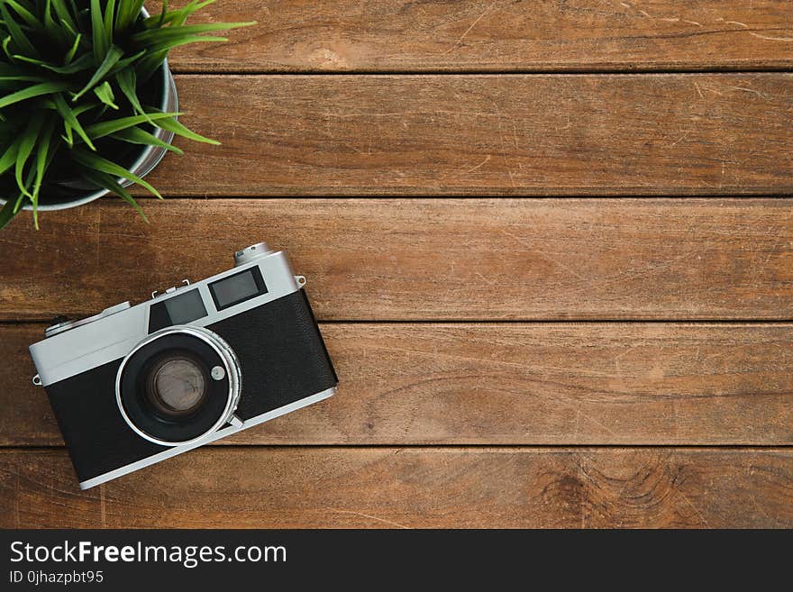 Black and Silver Film Camera on Brown Wooden Surface