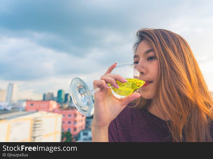 Woman in Purple Top Drinking on Clear Wine Glass