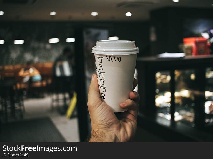 Person Holding Labeled Disposable Cup