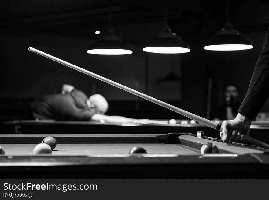 Grayscale Photo of Man Holding Cue-stick