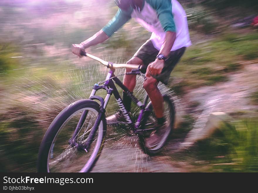 Man Riding Black and White Hardtail Mountain Bike