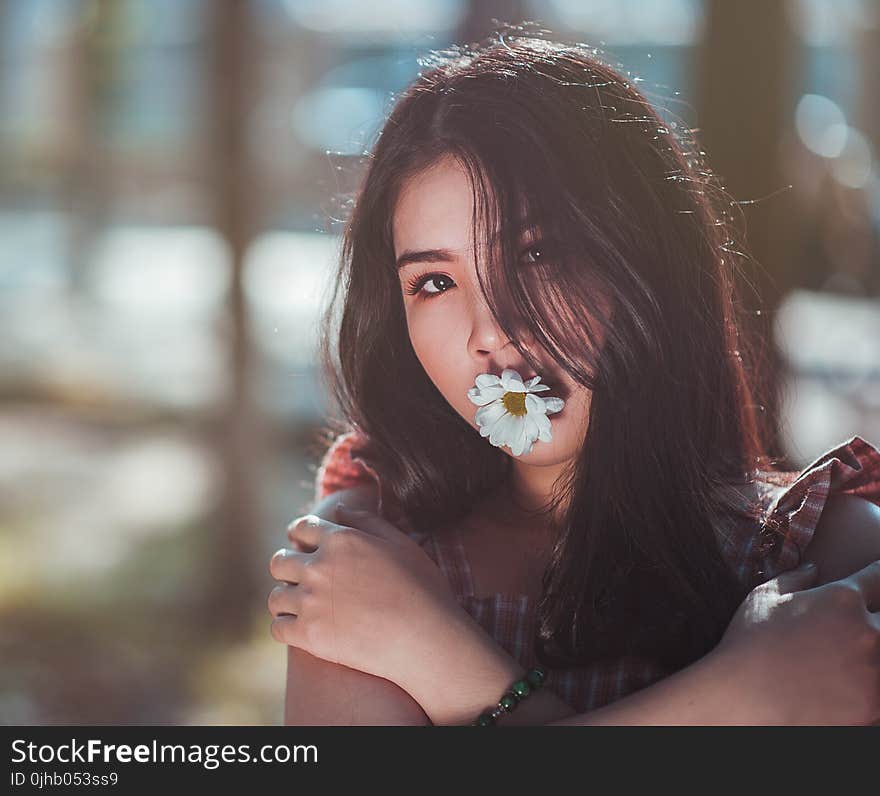 Close-up Photo of Woman in Brown Sleeveless Top With White Daisy Flower