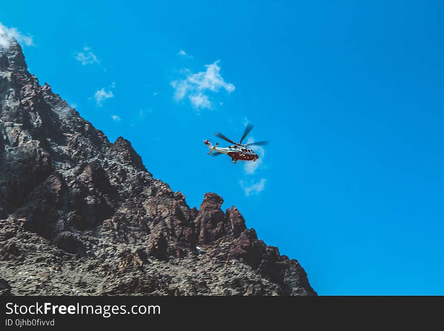 Photography of White and Red Helicopter Flying