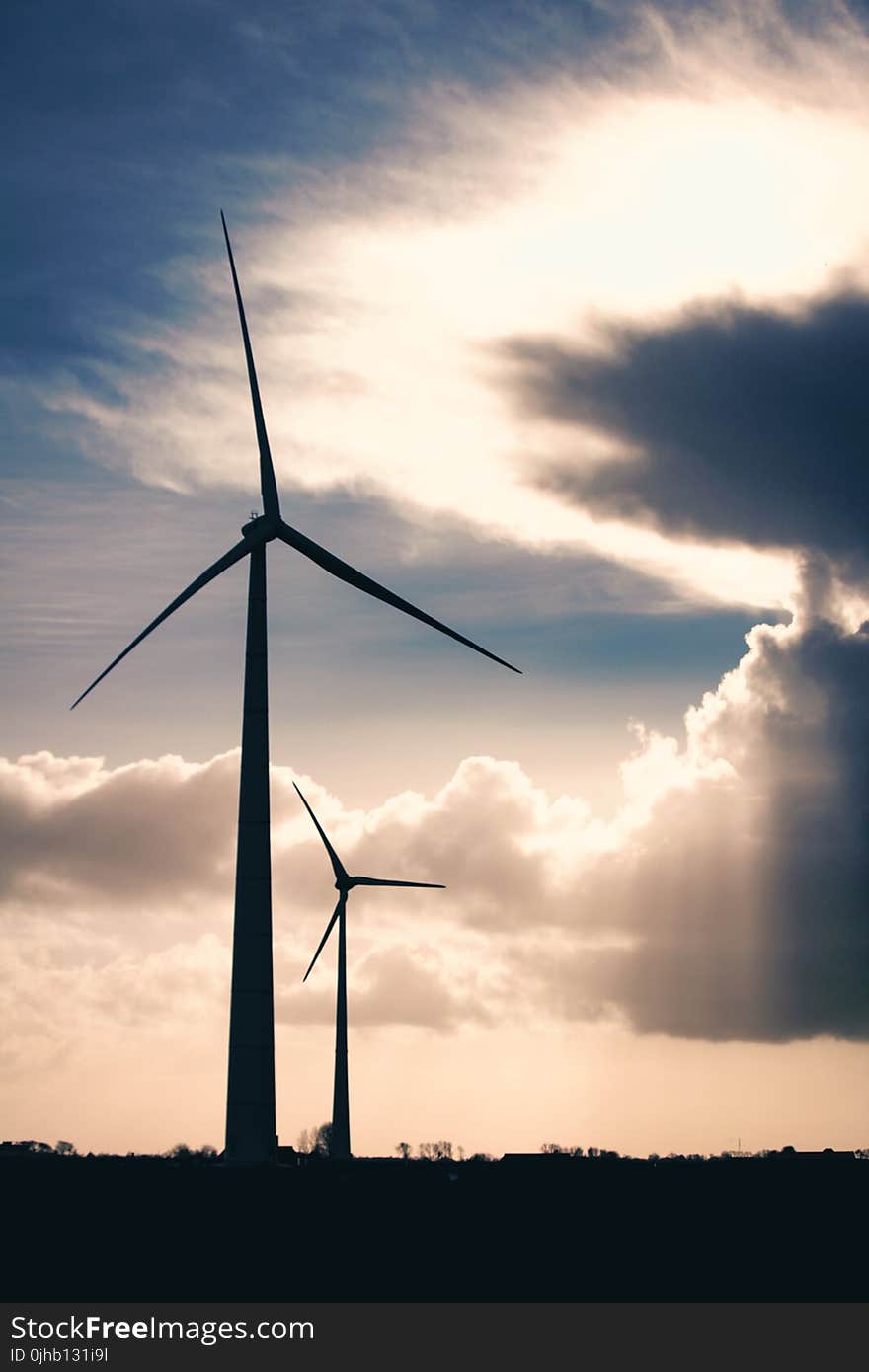 Silhouette Photo of Two Wind Mills during Golden Hour