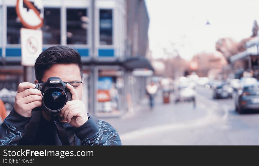 Man Holding A Camera On Busy Street