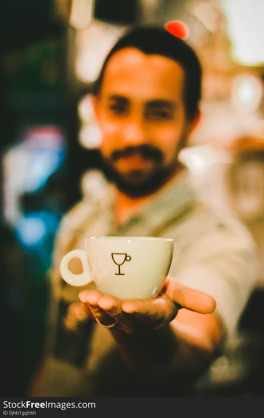 Focus Photography of Man Holding Ceramic Teacup