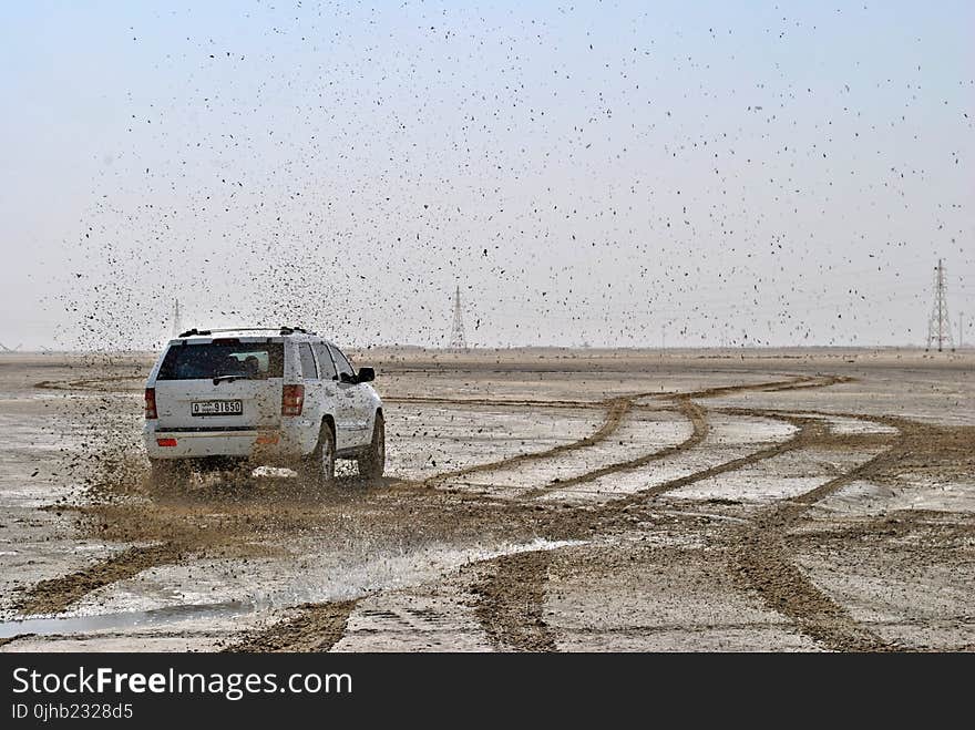 Photo of White Suv on Muddy Plain