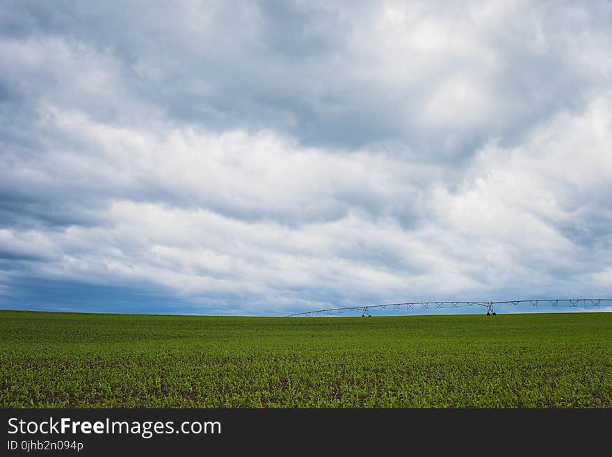 Green Grass Field Under Cumulonimbus Clouds