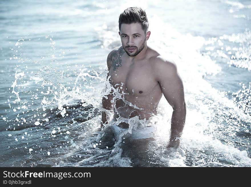 Photo of Man in Body of Water Wearing White Brief