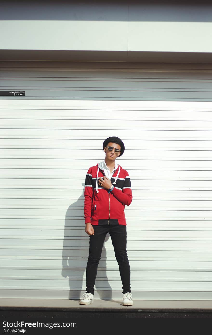 Man In Red And Black Zip-up Jacket And Black Pants With Black Hat