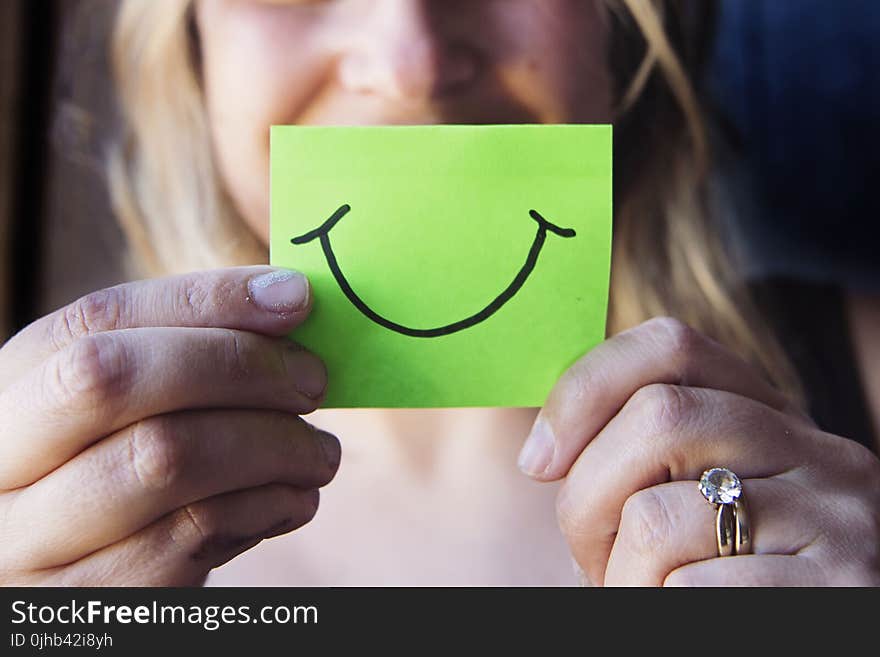 Photo of Woman Holding a Green Paper