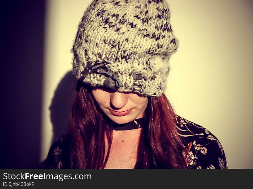 Woman Wearing Black and Gray Knit Cap in the White Wall Paint Room