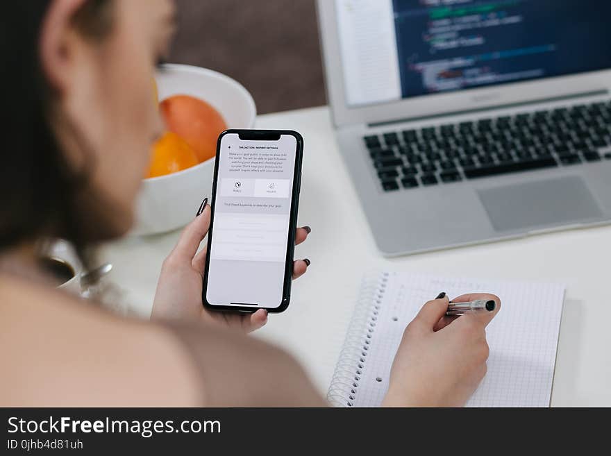 Women Holding Space Gray Iphone X and Black Pen