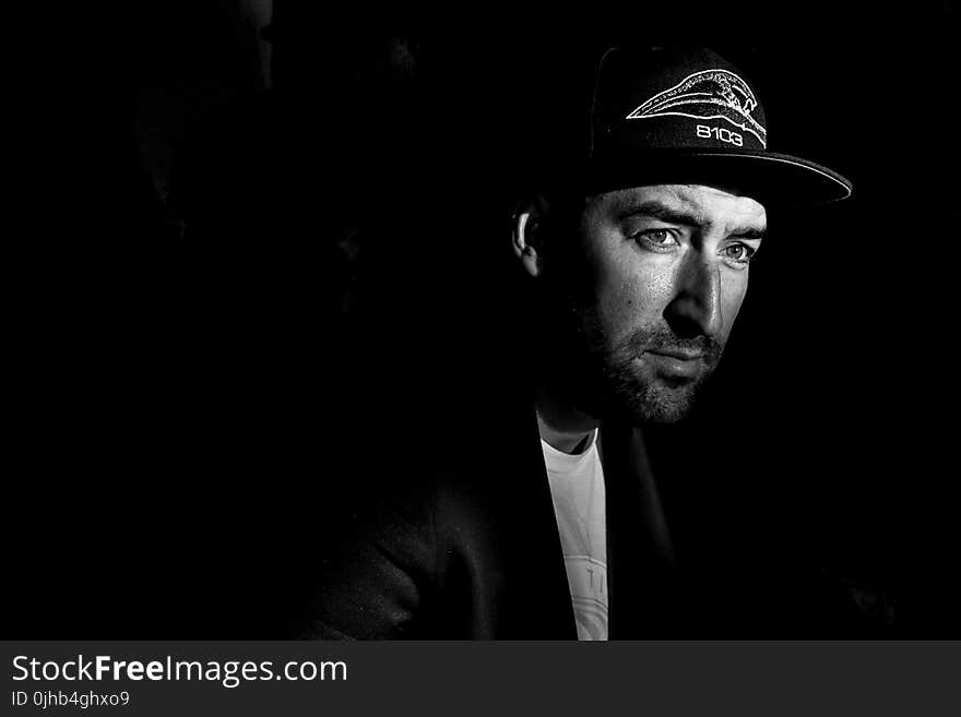 Grayscale Photo Portrait of Man in Black Cap