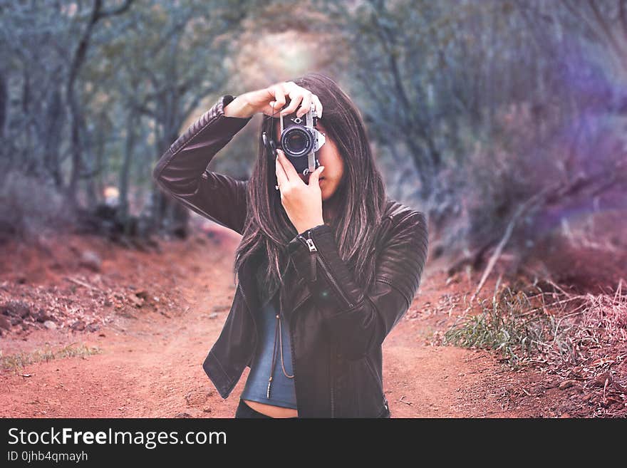 Woman Wearing Black Leather Jacket Holding Camera