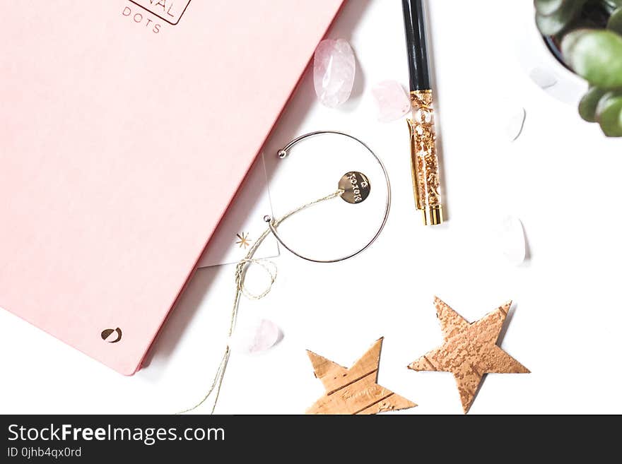 Silver-colored Open-end Bracelet Beside Two Brown Stars Ornament