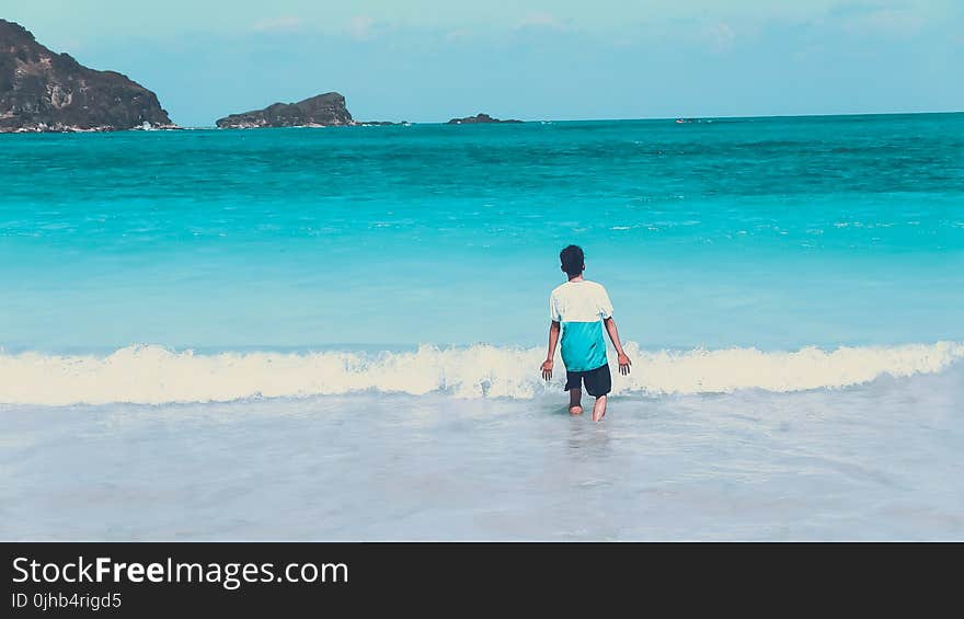 Photo of Man Walking by the Seashore