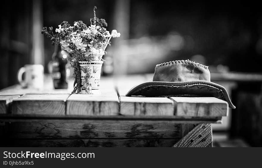 Grayscale Photography of Hat on Wooden Table