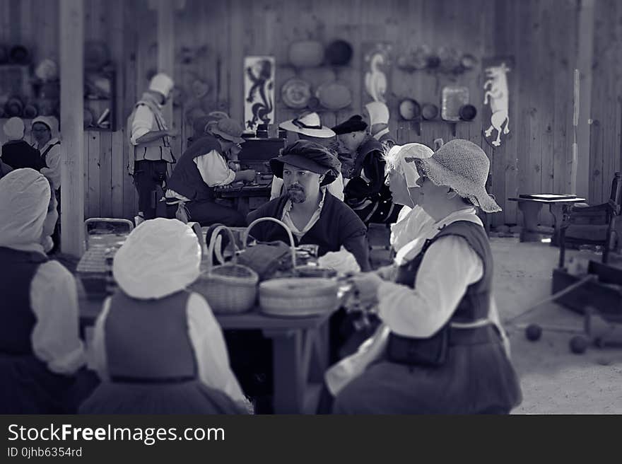 Man Sitting Between Female Near Table