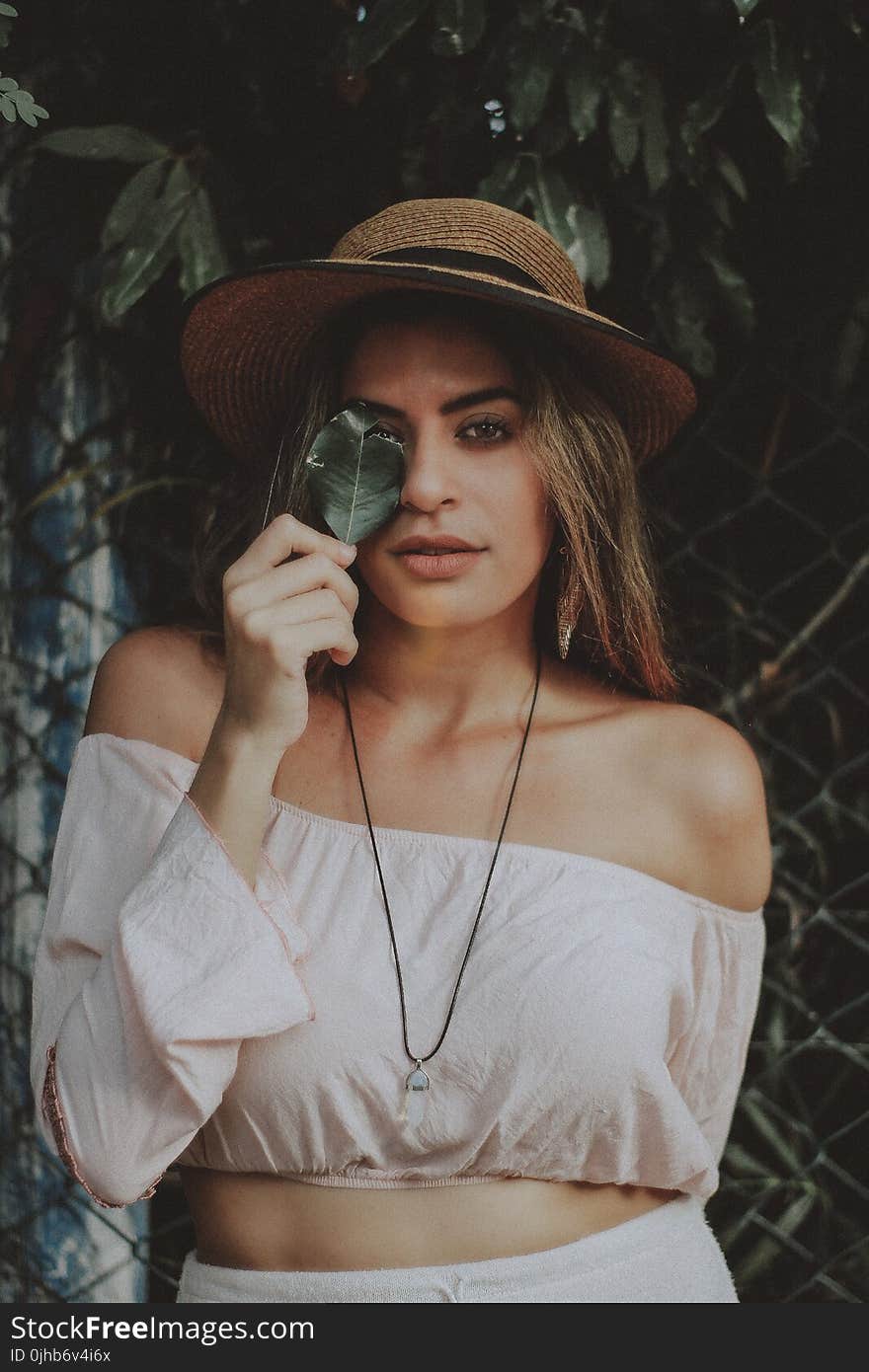 Woman in Crop Top Holding Leaf Covering Right Eye