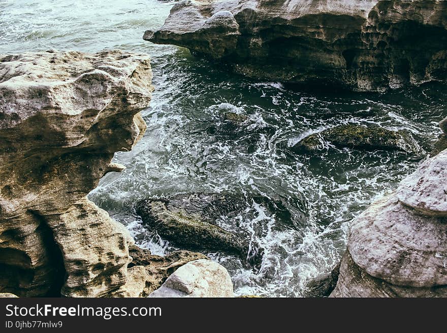 Brown Rock Formation Near Body of Water