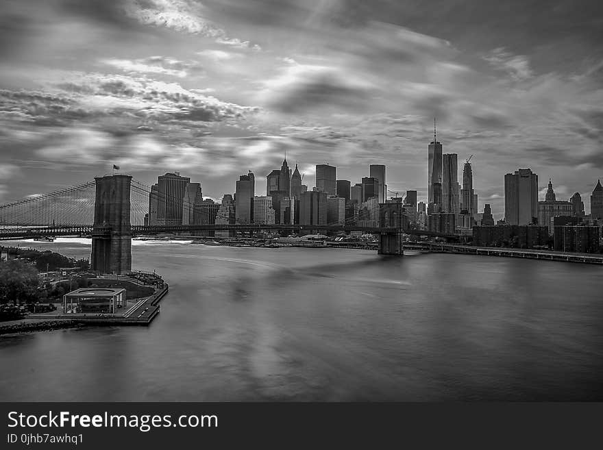 Grayscale Photography of City Buildings and Bridge