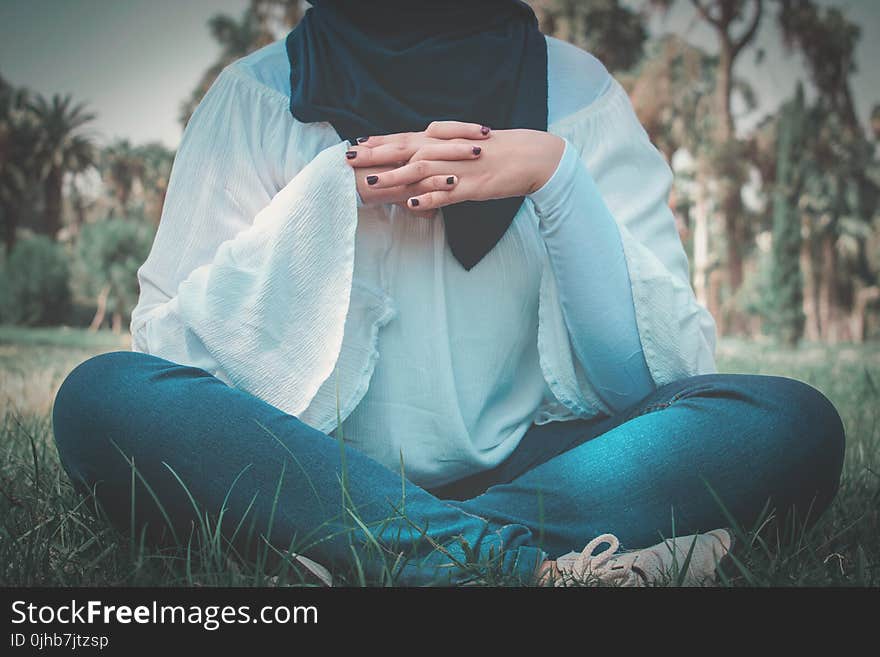 Woman in White Long-sleeved Shirt Sitting on Grass